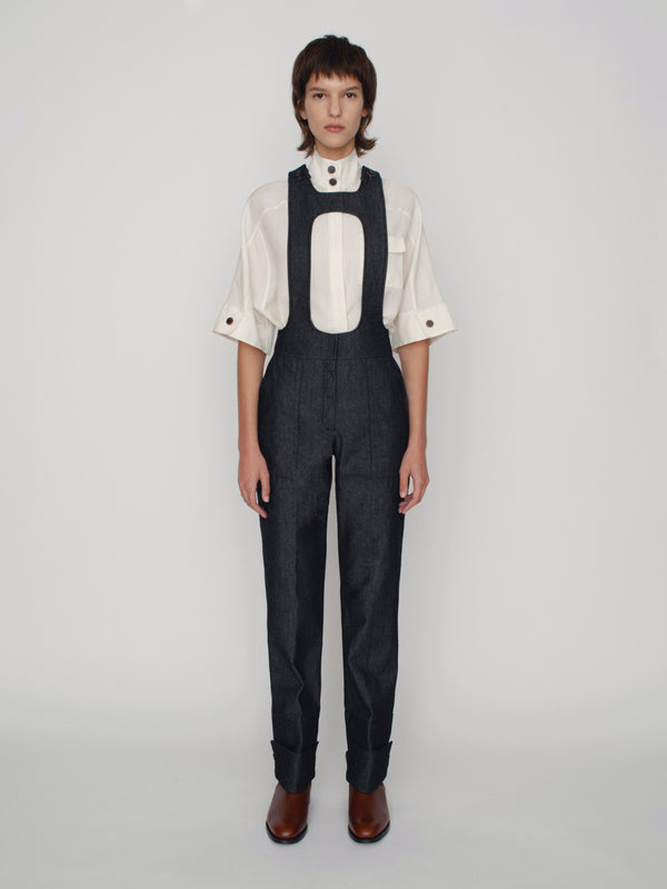Tailored overalls with oval shape straps and cuff details on the hem