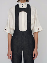 Tailored overalls with oval shape straps and cuff details on the hem